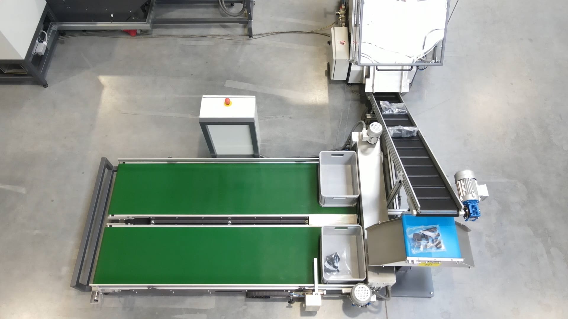 Widok z góry na dodatkowy mechanizm pakowania zbiorczego w maszynie pakującej. Przyśpiesza on proces pakowania, układania i przygotowywania worków do transportu.